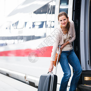 美丽的年轻女子登上火车速度平台女性游客铁路大厅行李城际女士运输图片