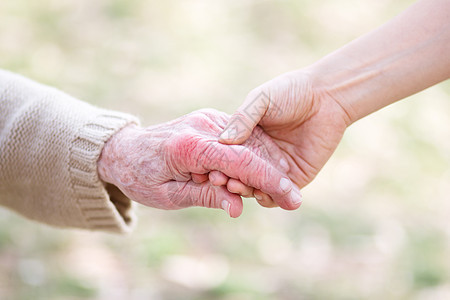 高级和青年妇女握手帮助老年双手照顾者手指祖母长老女性团结绿色图片