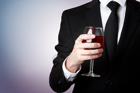 年轻男子拿着一杯红酒庆典器皿派对玻璃男性奢华饮料人士领带男人图片