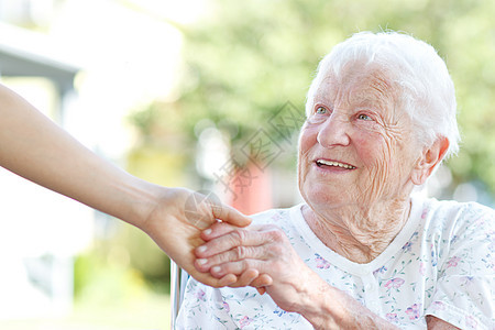 高级女性与看守人握手长老友谊车轮双手照顾者护理成人女士椅子房子图片