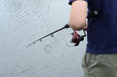 男孩在贝斯大坝或湖泊捕鱼渔夫青年男生运动孩子童年低音爱好闲暇卷轴图片