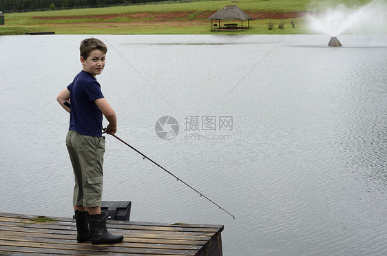 男孩在大坝或湖码头捕鱼钓鱼乐趣渔夫男生男性童年低音孩子爱好池塘图片