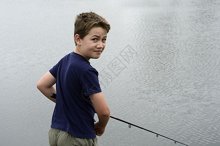 男孩在贝斯大坝或湖泊捕鱼娱乐青年假期钓鱼池塘码头乐趣孩子男生孩子们图片