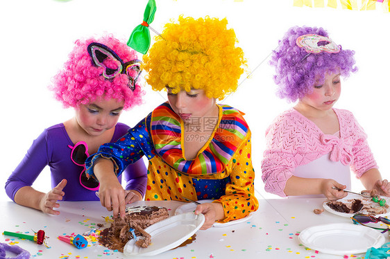孩子们生日派对快乐 吃巧克力蛋糕的小孩假发童年生日小丑派对蜡烛团体享受手势幸福图片