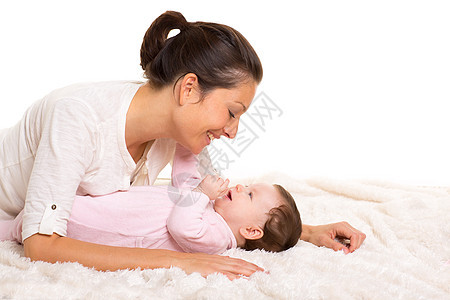 女孩和母亲的幸福快乐地一起玩耍婴儿拥抱帮手童年母性说谎棉被后代父母毯子图片