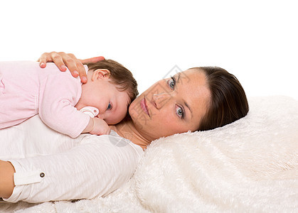 婴儿女孩和母亲在白毛皮上幸福地躺在一起奶嘴女士童年家庭女孩快乐毯子毛皮工作室棉被图片