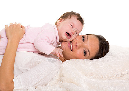 婴儿女孩哭泣 母亲躺在一起躺在白皮上图片