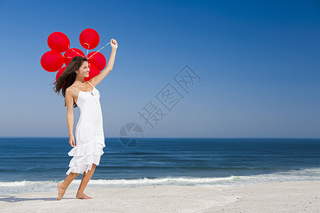 带着红色芭蕾舞的漂亮女孩海滩飞行成人幸福天空女性享受乐趣蓝色气球图片