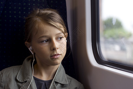 女孩在火车上窗户孩子青少年教练交通公共汽车耳机电车旅行图片