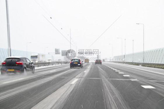 在荷兰暴风雪中驾驶A10高速公路的汽车图片