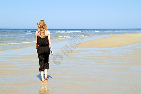 海滩上美丽的年轻金发美女头发享受太阳假期蓝色快乐比基尼女性天空女士图片