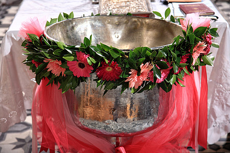 带有花装饰的洗礼碗符号白色绿色温暖桌子粉红色面纱作品仪式花朵图片