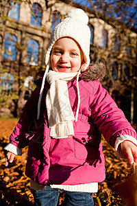 秋天在户外玩耍的可爱女孩橙子围巾公园孩子活动童年夹克季节乐趣闲暇图片