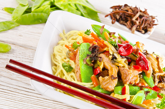 带猪肉和蔬菜的面条辣椒炒锅李子竹子筷子盘子食物食品胡椒树叶图片