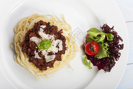 配肉酱和烤肉的意大利面勺子沙拉牛肉糖类叶子刀具美食肉汁玻璃盘子图片