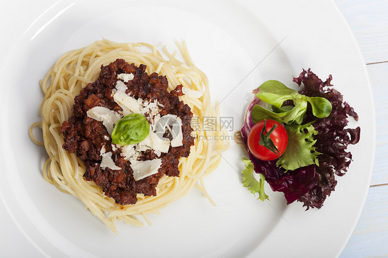 配肉酱和烤肉的意大利面勺子沙拉牛肉糖类叶子刀具美食肉汁玻璃盘子图片