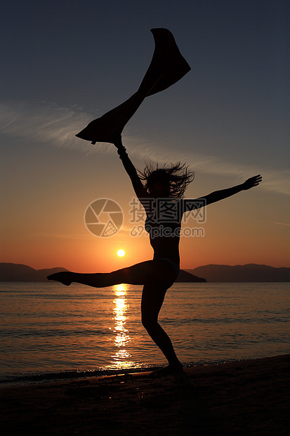 海滩上一个女孩的背影毛巾天空蓝色女性跑步舞蹈家太阳女士舞蹈跳跃图片