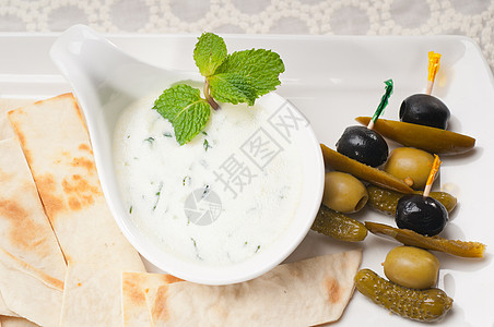 希腊语 Tzatziki 酸奶酱和皮塔面包薄荷盘子黄瓜美食饮食蔬菜面包草本植物营养奶制品图片