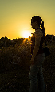 妇女日落光影女孩黄色马尾太阳太阳镜场地乐趣休息天空女士背景图片