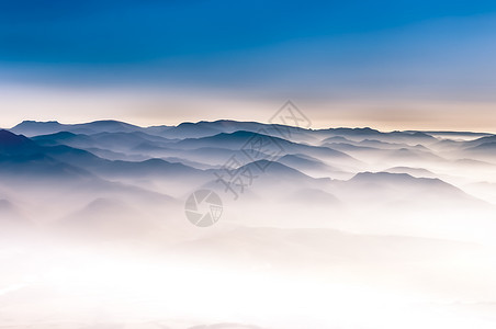 蓝色天空的薄雾山地风景图片