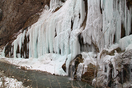 岩石上美丽的冰柱溪流蓝色瀑布石头流动白色荒野棕色图片