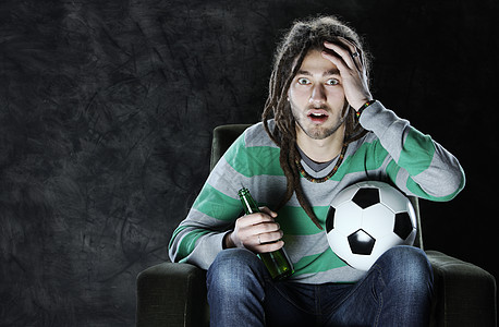 在电视上看足球运动文化热情辫子男人瓶子年轻人青年活动扇子图片