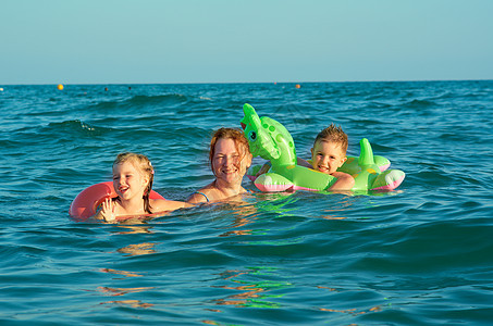 在波浪中的家庭孩子海浪童年季节喜悦假期晴天乐趣海滩海洋图片