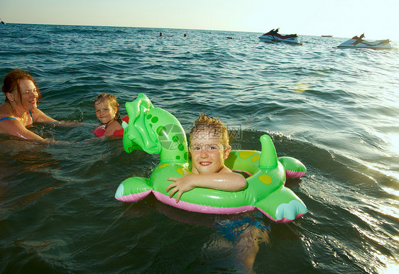 在波浪中的家庭假期季节喜悦晴天海浪海滩乐趣女孩海洋童年图片