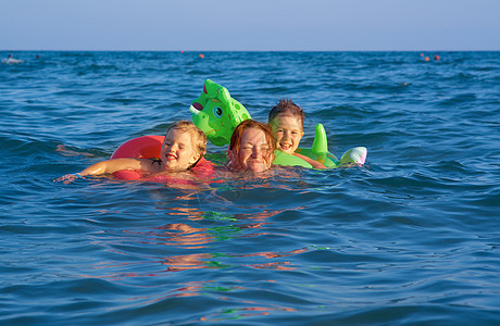 在波浪中的家庭晴天海浪童年假期海洋蓝色孩子海滩季节喜悦图片