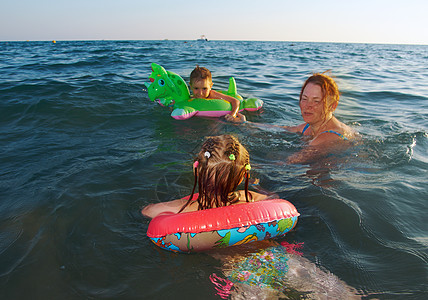 在波浪中的家庭海浪晴天女孩假期海滩童年孩子喜悦乐趣季节图片