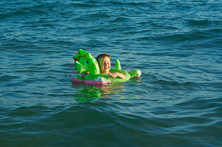 在海浪中的小男孩喜悦童年晴天孩子蓝色季节假期海滩乐趣海洋图片