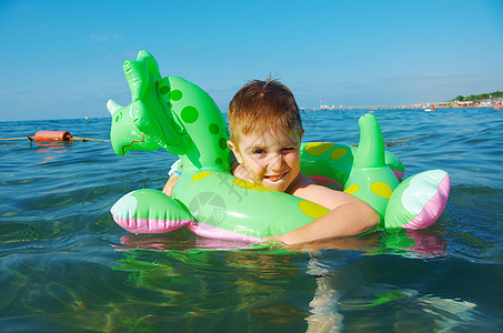 在海浪中的小男孩乐趣海滩喜悦蓝色季节童年假期孩子海洋晴天图片