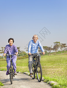 快乐的亚洲老人 在公园骑双车背景图片