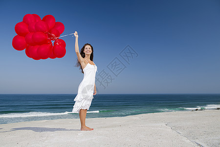 带着红色芭蕾舞的漂亮女孩海滩蓝色气球自由幸福女性快乐微笑飞行喜悦图片