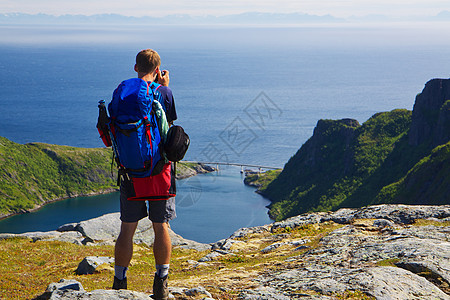 挪威全景峡湾运动首脑闲暇顶峰海洋蓝色男人风景背包图片