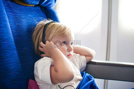 飞机上带耳机的孩子技术立体声女孩旅游女儿天空旅行假期乘客椅子图片