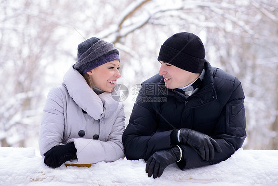 年轻微笑的情侣在雪上撒谎的肖像女性女士成人男性女孩拉伸男人白色快乐家庭图片