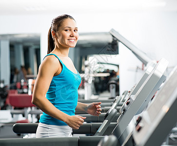 有魅力的年轻女子骑脚踏车跑步成人运动服俱乐部赛跑者机器有氧运动健身房训练喜悦运动图片