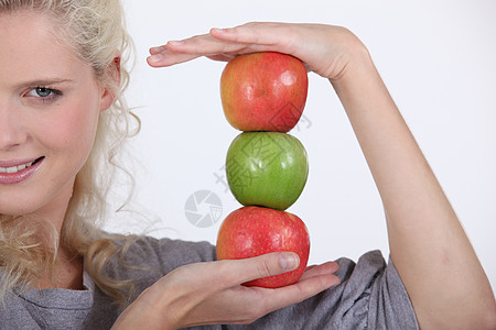 女人拿着一堆苹果紧缩奶奶营养金发女郎手掌杯状金发小吃绿色食物图片