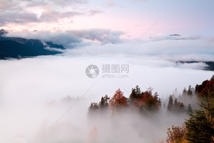 在阿尔卑斯山的雾中日出图片