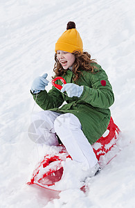 女孩骑着雪橇下山图片