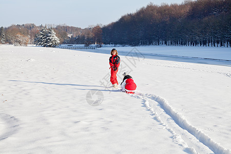 母亲和女儿在下雪的冬季公园白色季节性女孩家庭闲暇女性夹克活动享受孩子图片