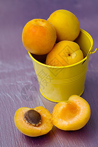 一个小黄桶中的杏子果汁食物水果农业木头维生素叶子工作室收成橙子图片