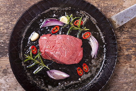 铁锅里生牛排烹饪辣椒烧烤鱼片香料黄油迷迭香乡村食物木头图片