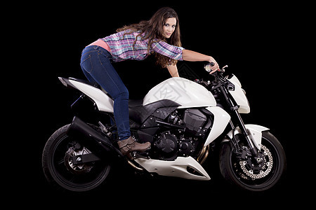 坐在一辆白色摩托车旁边的漂亮女孩车辆速度女孩牛仔裤齿轮发动机机器女性自行车衬衫图片