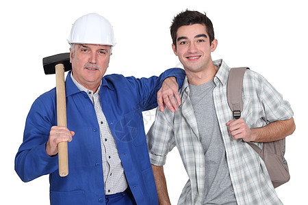 一位成熟的建筑工人和他的孙子硬件建设者安全背包学徒金属雪橇大锤建造头盔图片