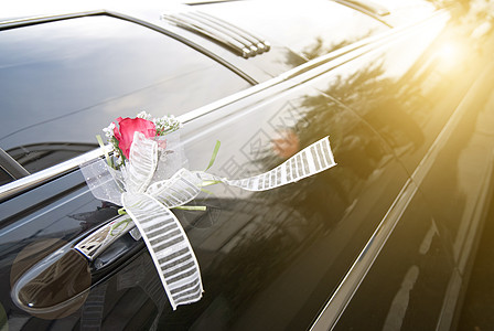 带花和丝带的黑色结婚轿车门仪式婚姻婚礼庆典奢华玫瑰夫妻运输装饰风格图片