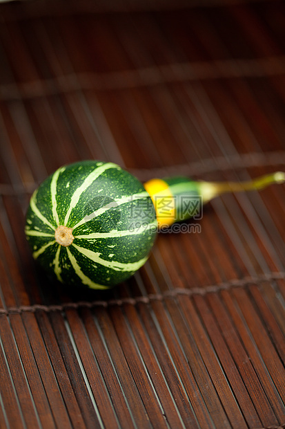 竹垫上的黄绿色中国南瓜工作室叶子摄影宏观食物南瓜竹子活力生活剪裁图片