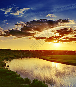 日落在河上场景金子晴天环境国家橙子天空芦苇射线太阳光线图片