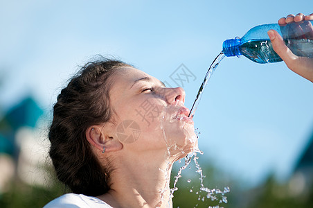 美丽的妇女饮用水 干渴女性流动慢跑口渴成人女孩活力运动有氧运动蓝色图片